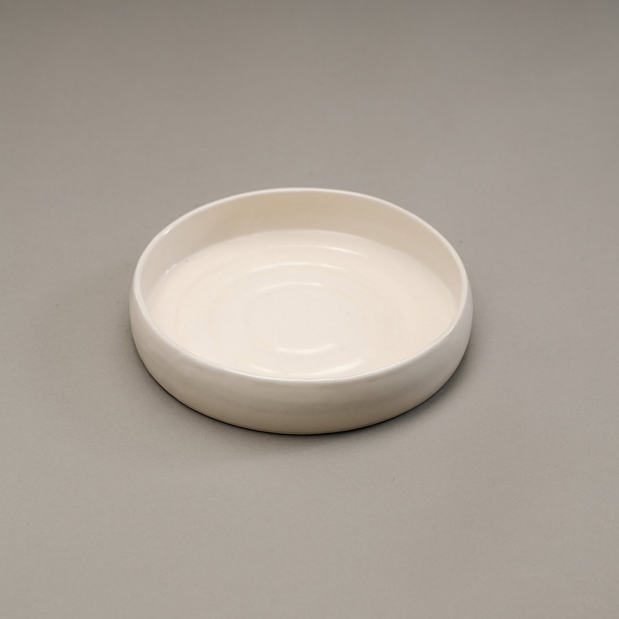 A stoneware salad plate in a white finish.