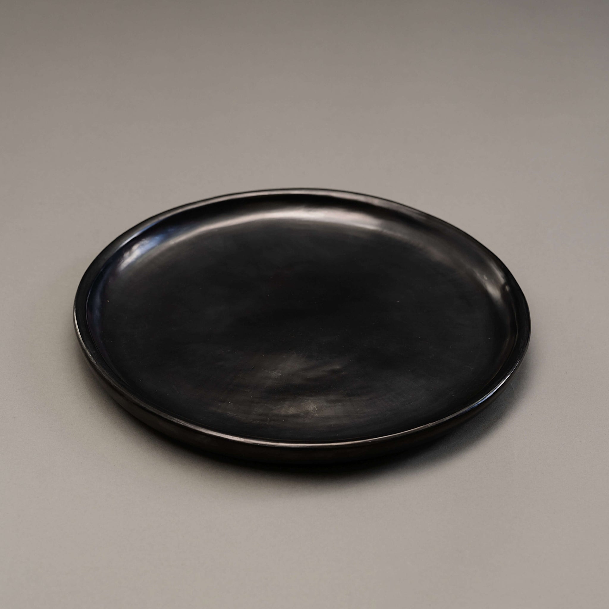 A side view of a black clay plate made in Oaxaca.