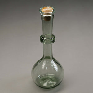 A small glass decanter with a corker stopper.