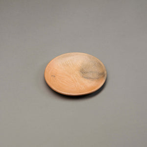 Smoky orange clay small plate side view.