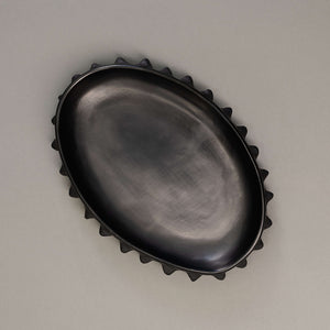 Spiky black clay oval shaped serving tray.