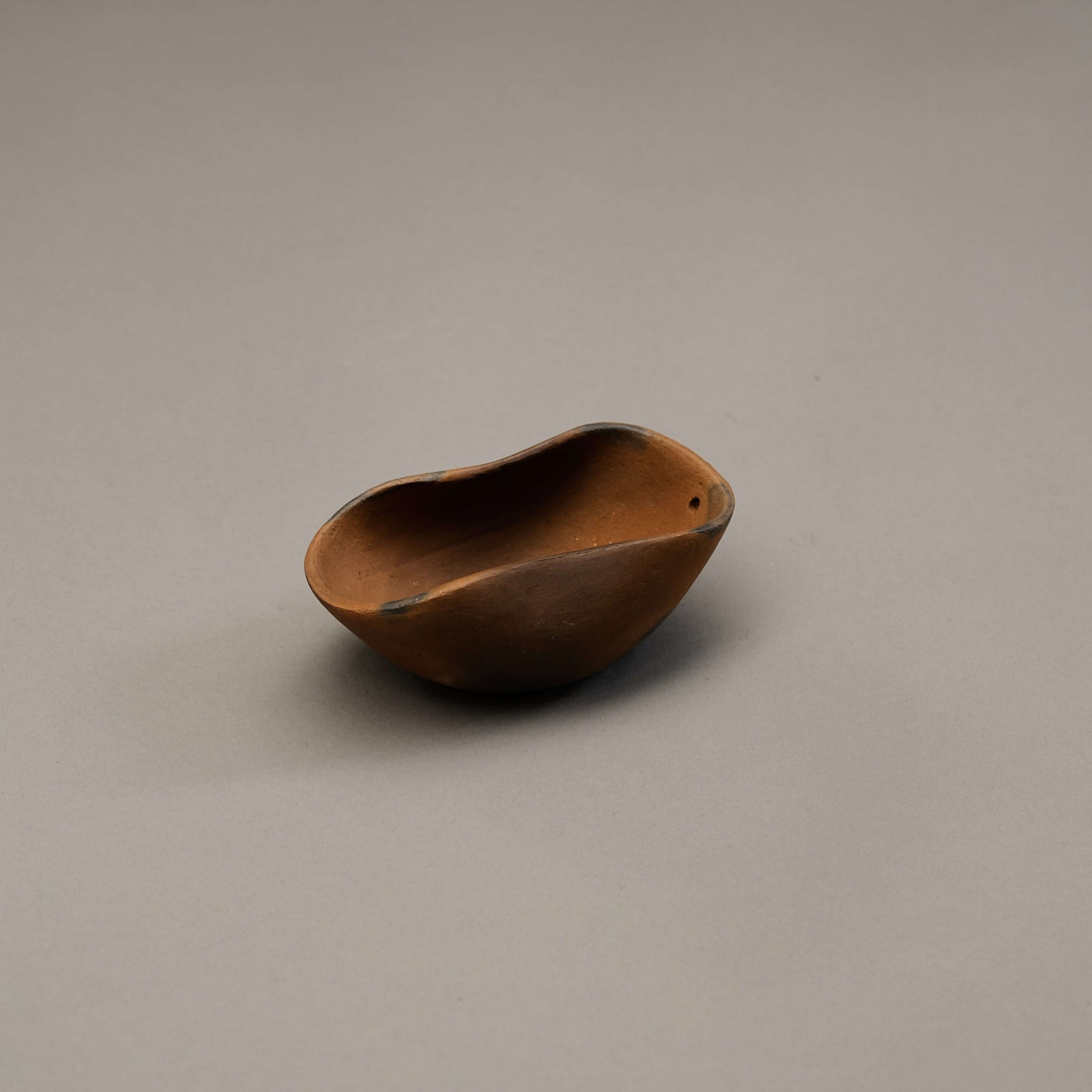 A sculptural incense holder made of clay.
