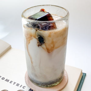 A large handblown glass tumbler with iced coffee.