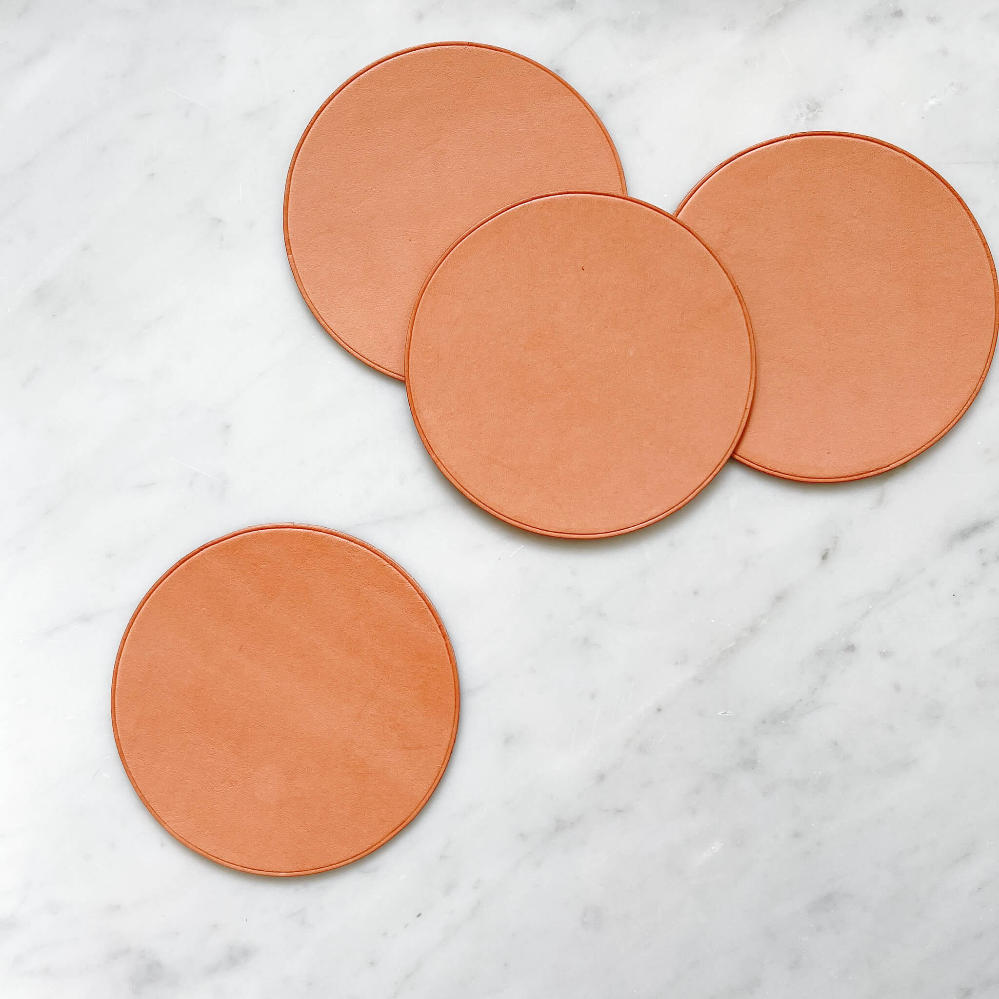 A set of 4 Baja leather coasters in natural nude.