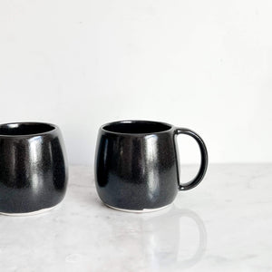 Black stoneware ceramic mug.