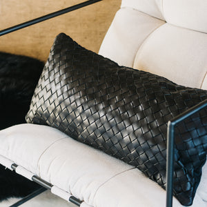 Details on a black woven leather lumbar pillow.