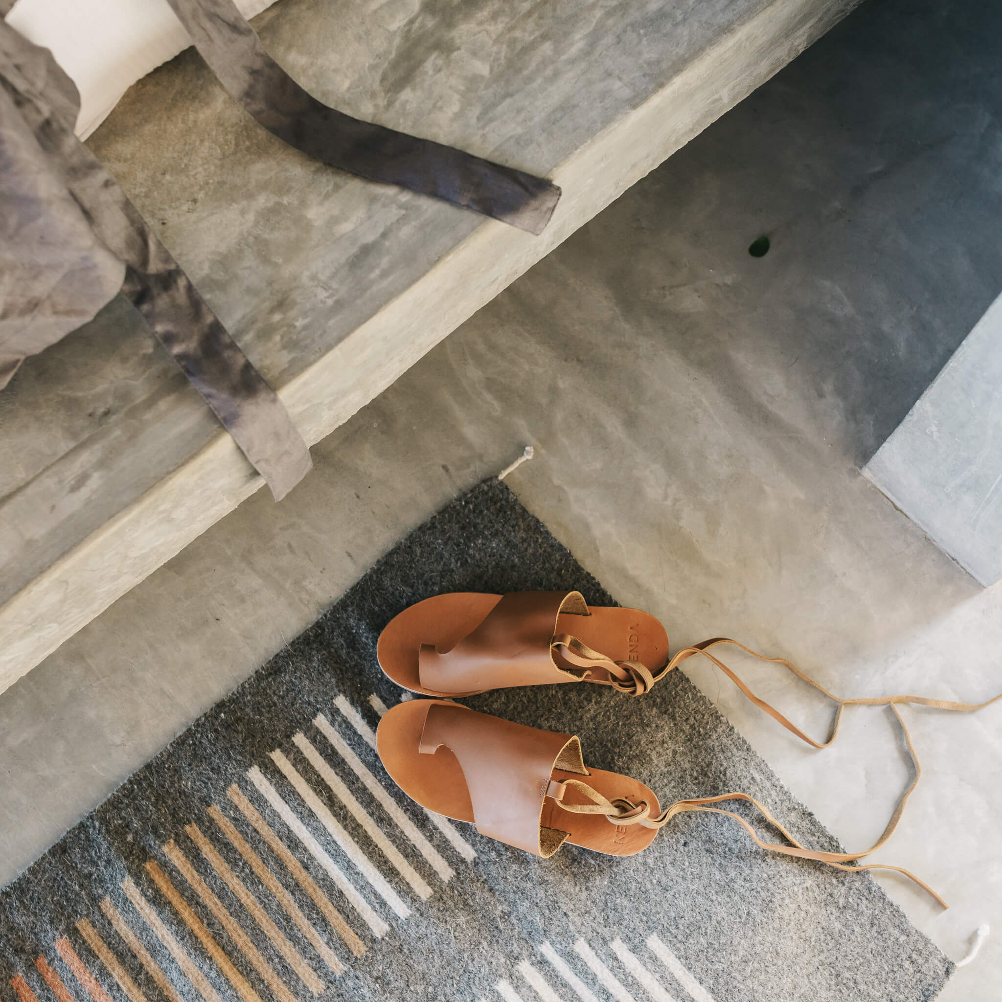The details on a desierto wool rug featured with a pair of leather sandals.