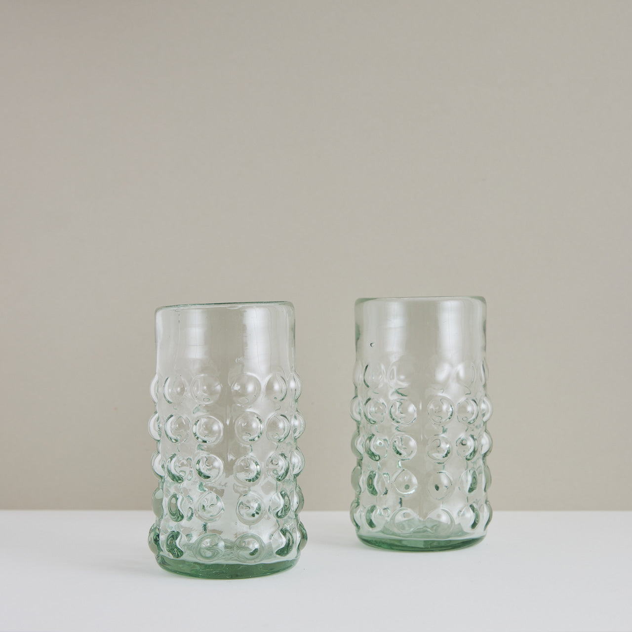 A pair of handblown hobnail glass tumblers made in Mexico.