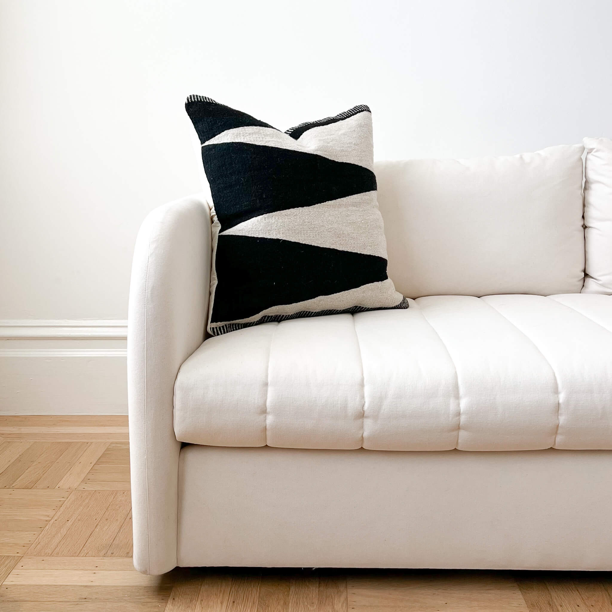 Hidalgo black and ivory throw pillow made in Mexico on an ivory couch.