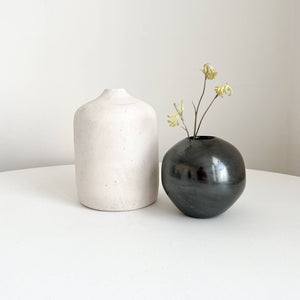 A white cilindro vase paired with a Mata Ortiz obsidian vase.