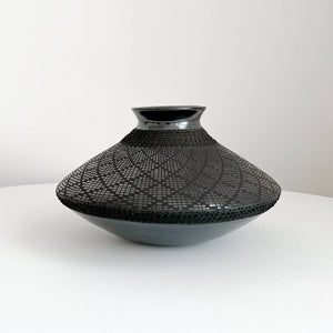 A Mata Ortiz spheroid shaped black clay vase.