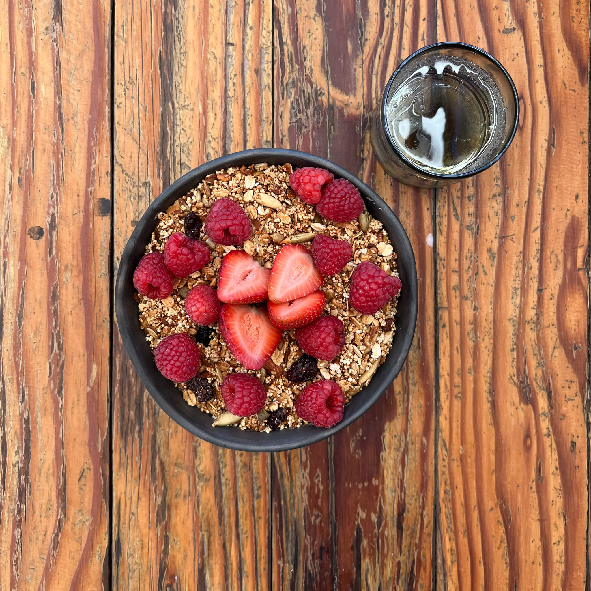 A Oaxaca black clay bowl holding granola with fruit.