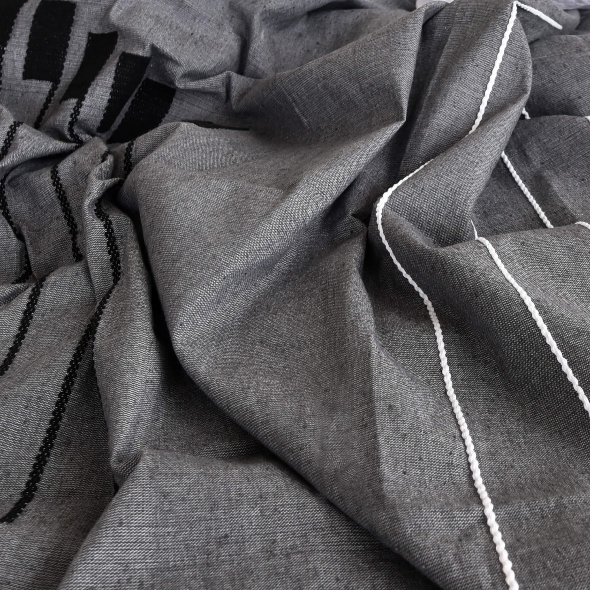 Handstitched details on a Oaxaca cotton dark gray coverlet.