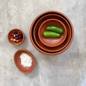 A selection of Oaxaca red clay pottery, including three nested red clay bowls, a salt bowl and an olive bowl.
