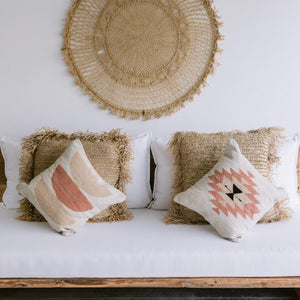 A pair of Oaxaca wool throw pillows on a white couch.