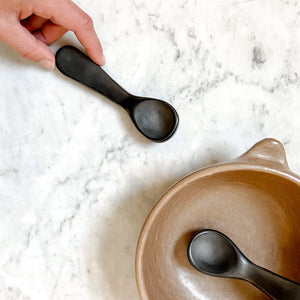 Oaxacan black clay, also known as barro negro, spoons on marble counter.