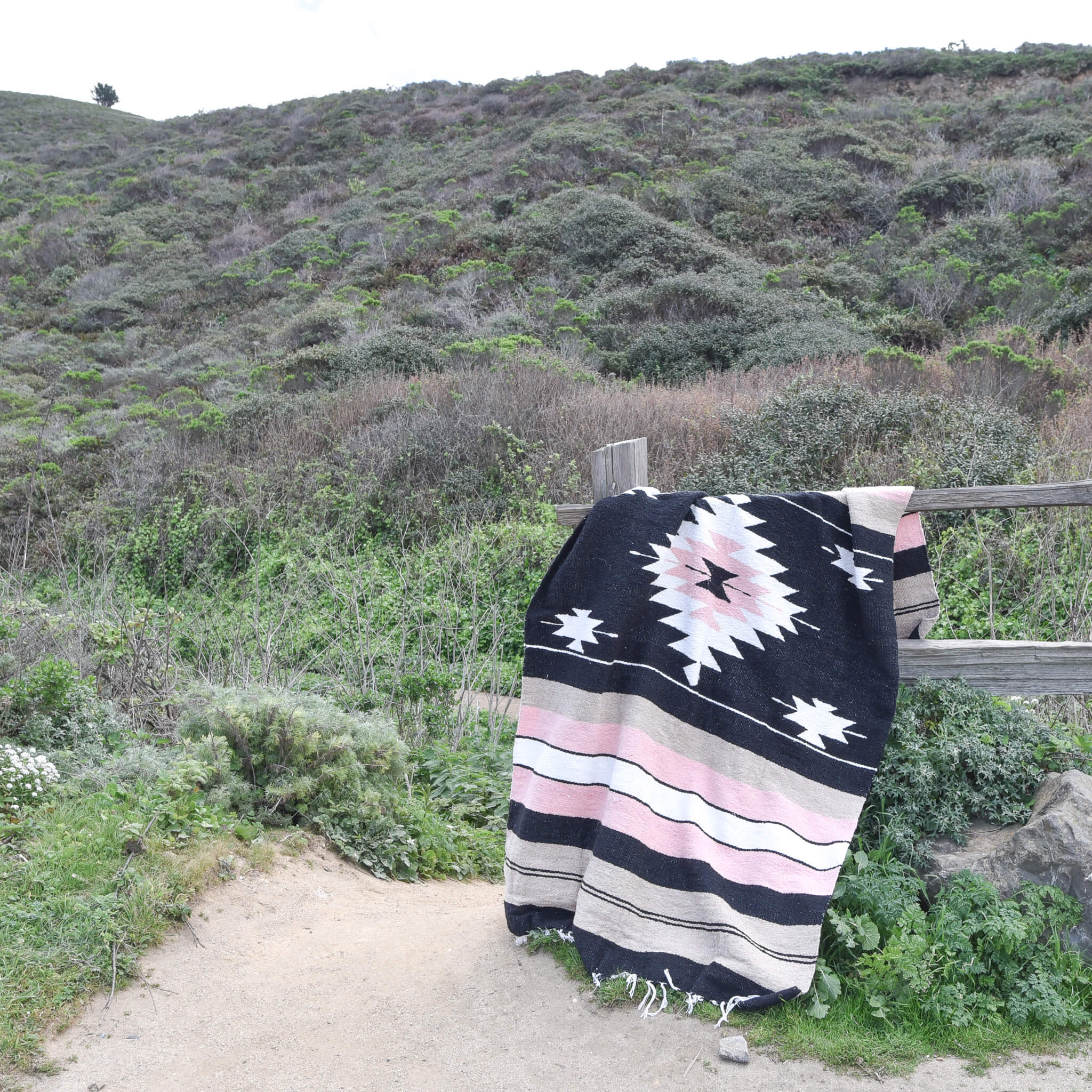 A Rosa Mexican blanket draped over a fence.
