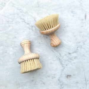 Sisal kitchen brushes on a white marble counter.