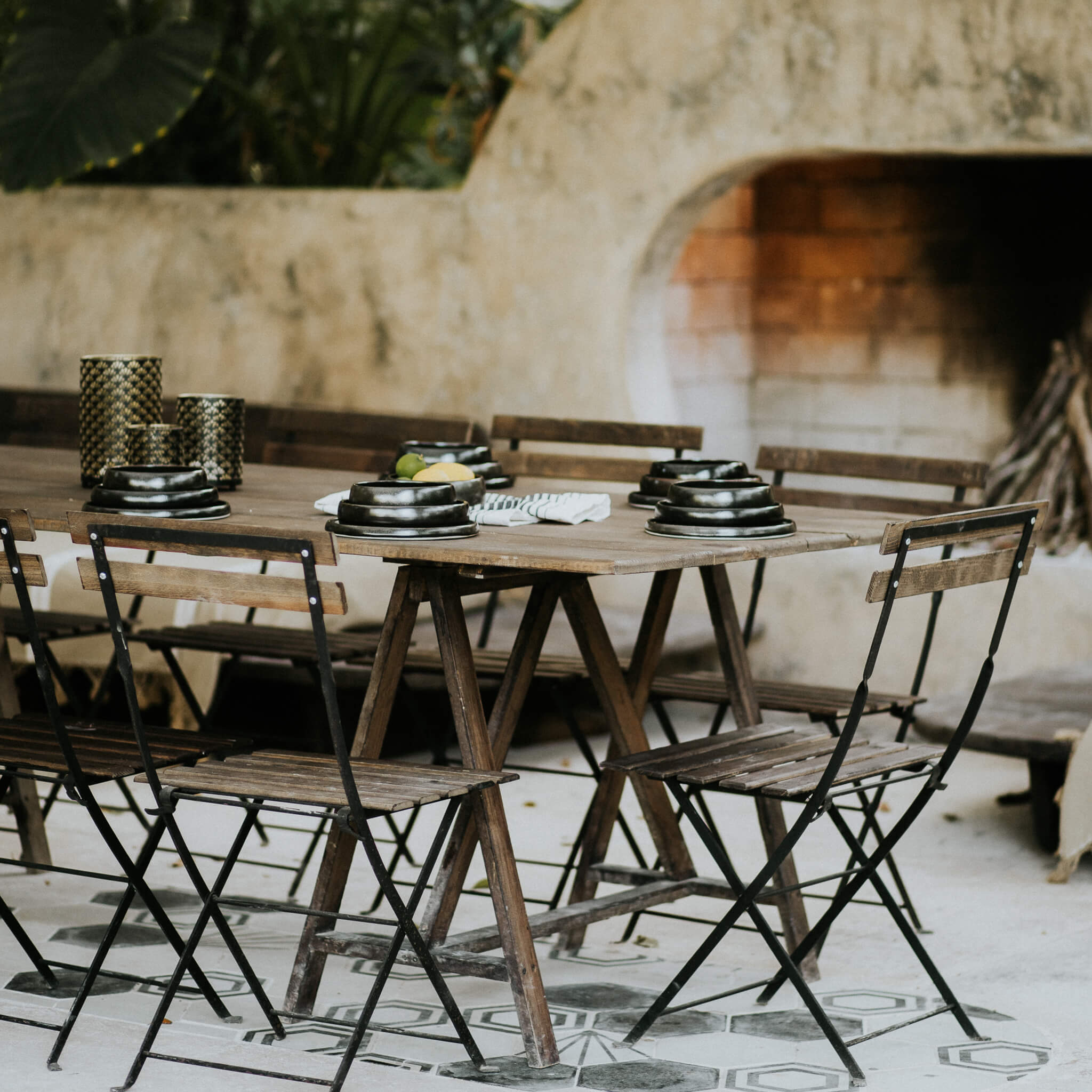 An outdoor table set with black stoneware dishes.