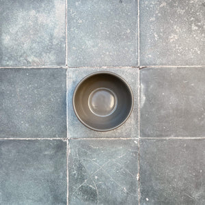 Terracotta gray snack bowl on gray tile.
