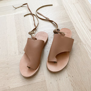 Leather nude sandals with an ankle tie.