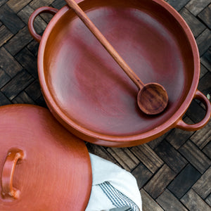 A Oaxaca red clay cazuela with a large serving spoon.