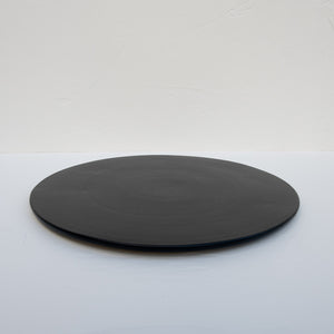 A matte-black stoneware serving platter.