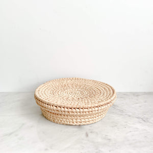 Tortillero palm basket made in Baja on a white marble counter.