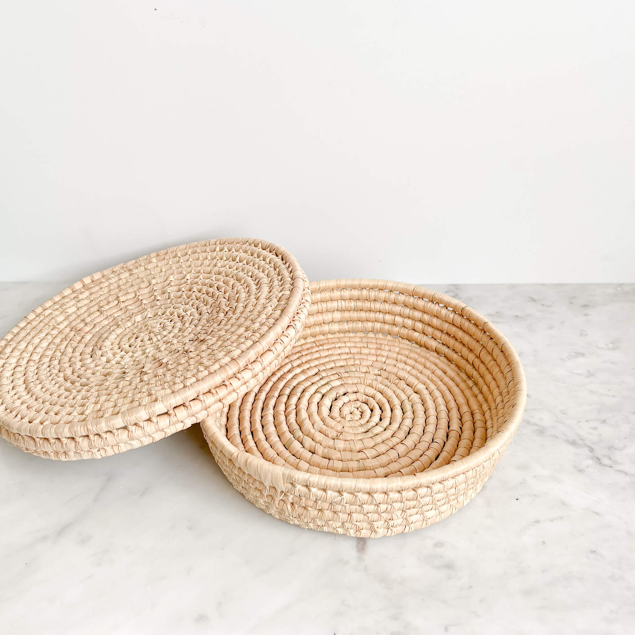 A tortillero tortilla basket handwoven in Baja, Mexico on a white marble counter.