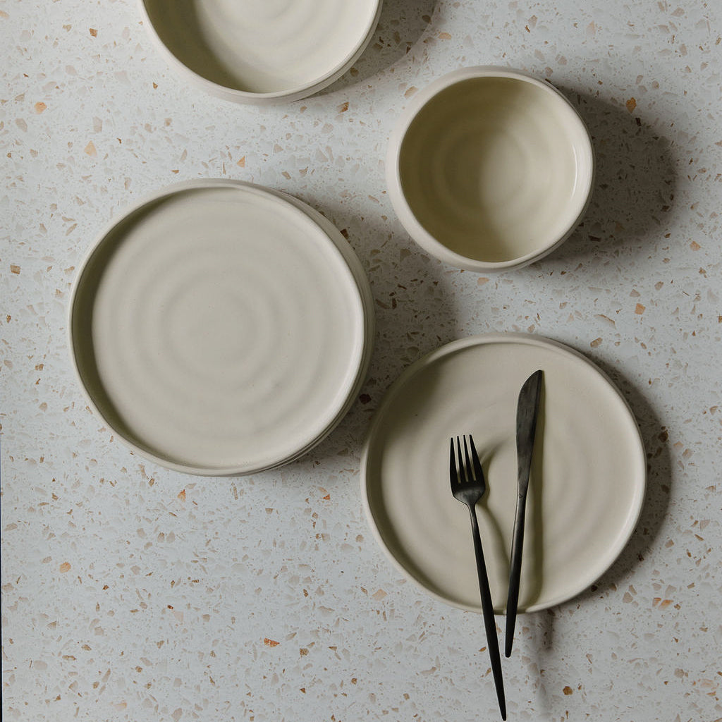 White ceramic dishes on a terrazzo counter.