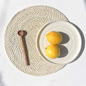 A white stoneware dinner plate with two lemons.