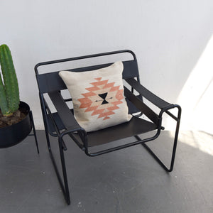 A Zapotec wool throw pillow on a black leather Wassily chair.